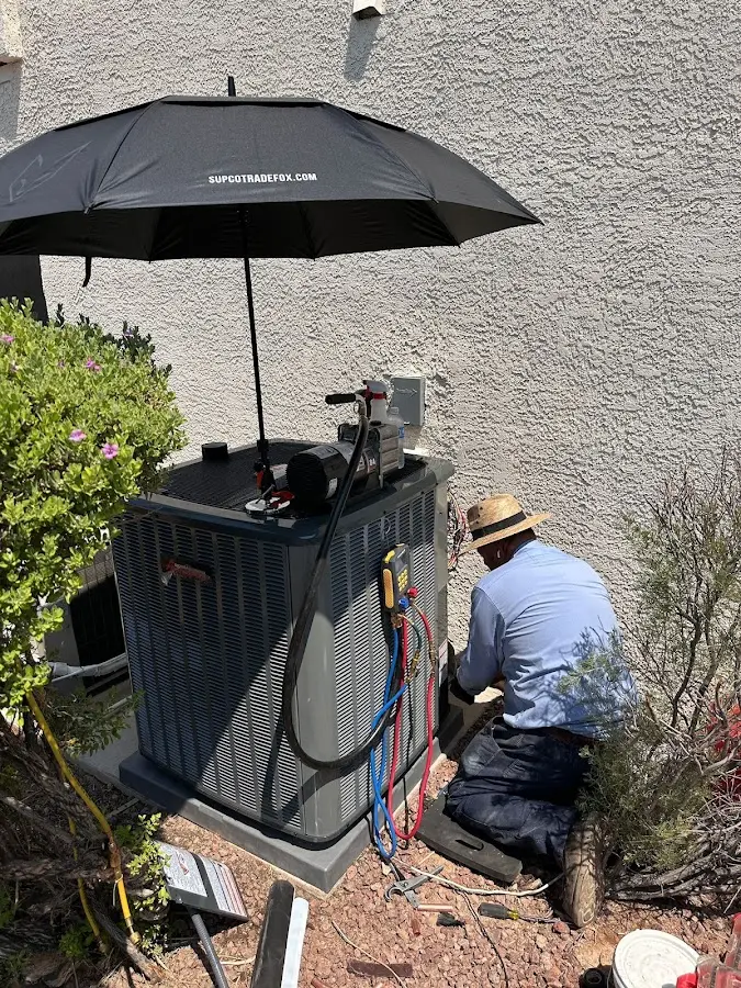 HVAC technician performing outdoor AC maintenance in Spring
